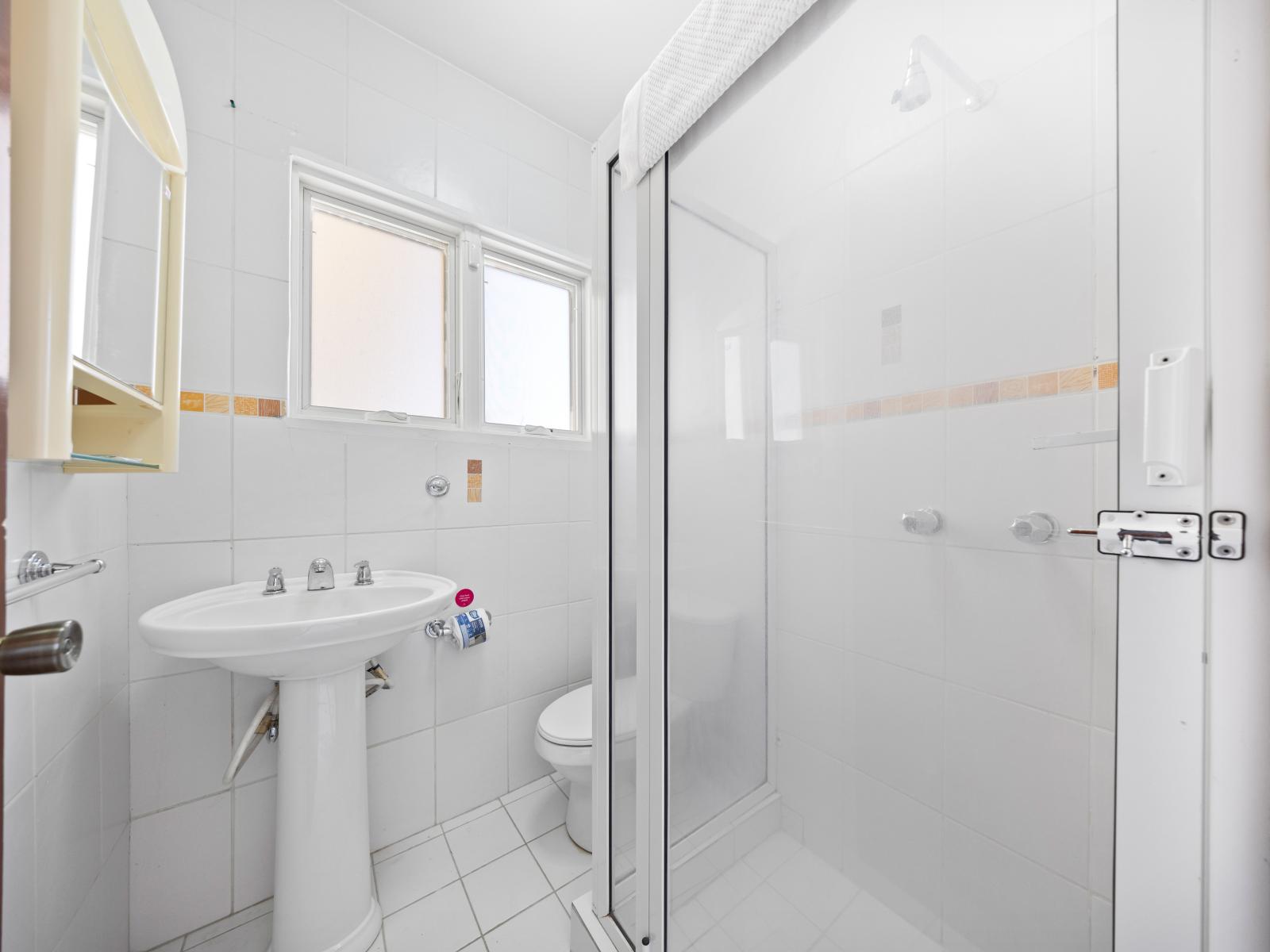 Discover convenience and modern luxury in Bathroom 3, featuring a sleek walk-in shower. Step into this contemporary oasis where stylish design meets functionality for a refreshing experience.