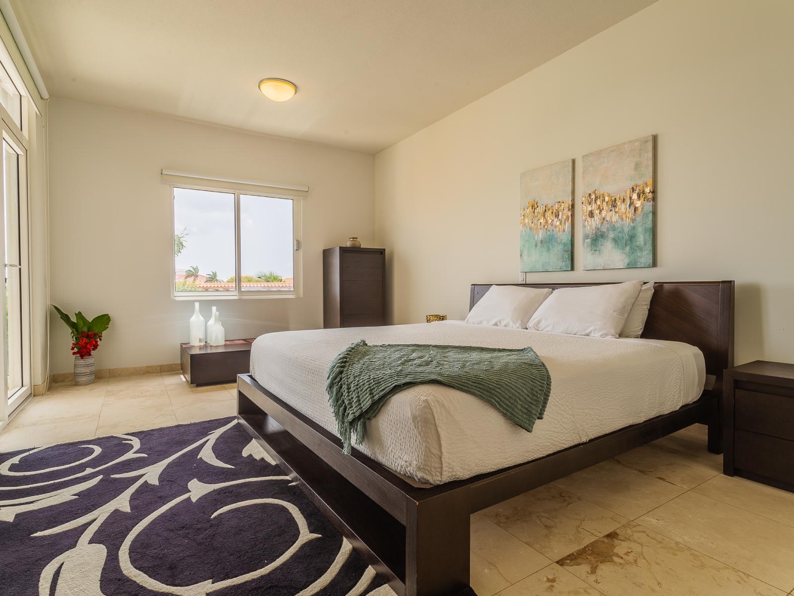 Deluxe Bedroom of the lovely condo in Oranjestad Aruba - King Size Bed - Spacious bedroom offering comfort and style - Cozy retreat with a plush bed, perfect for relaxation - Bright and airy bedroom with large windows - Smart TV and Netflix