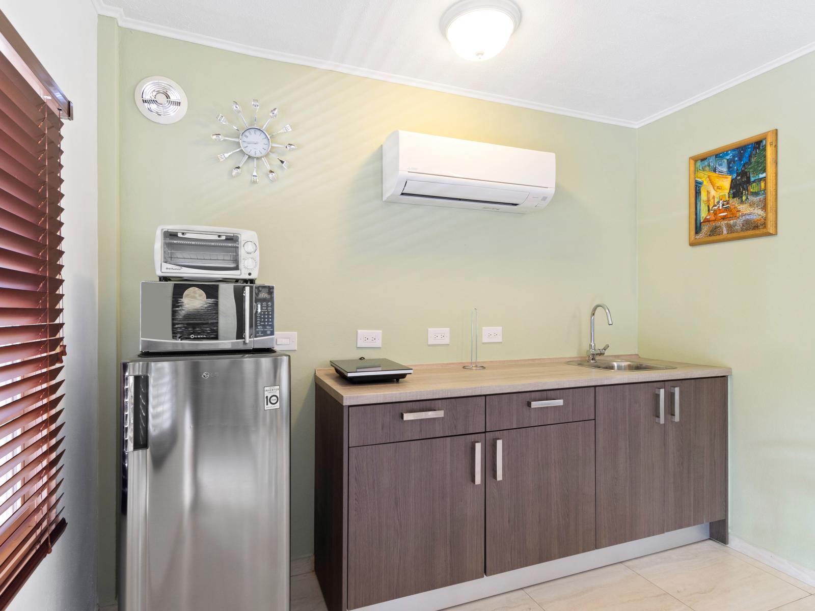 Private kitchen equipped with a fridge, small stove top, oven and microwave.