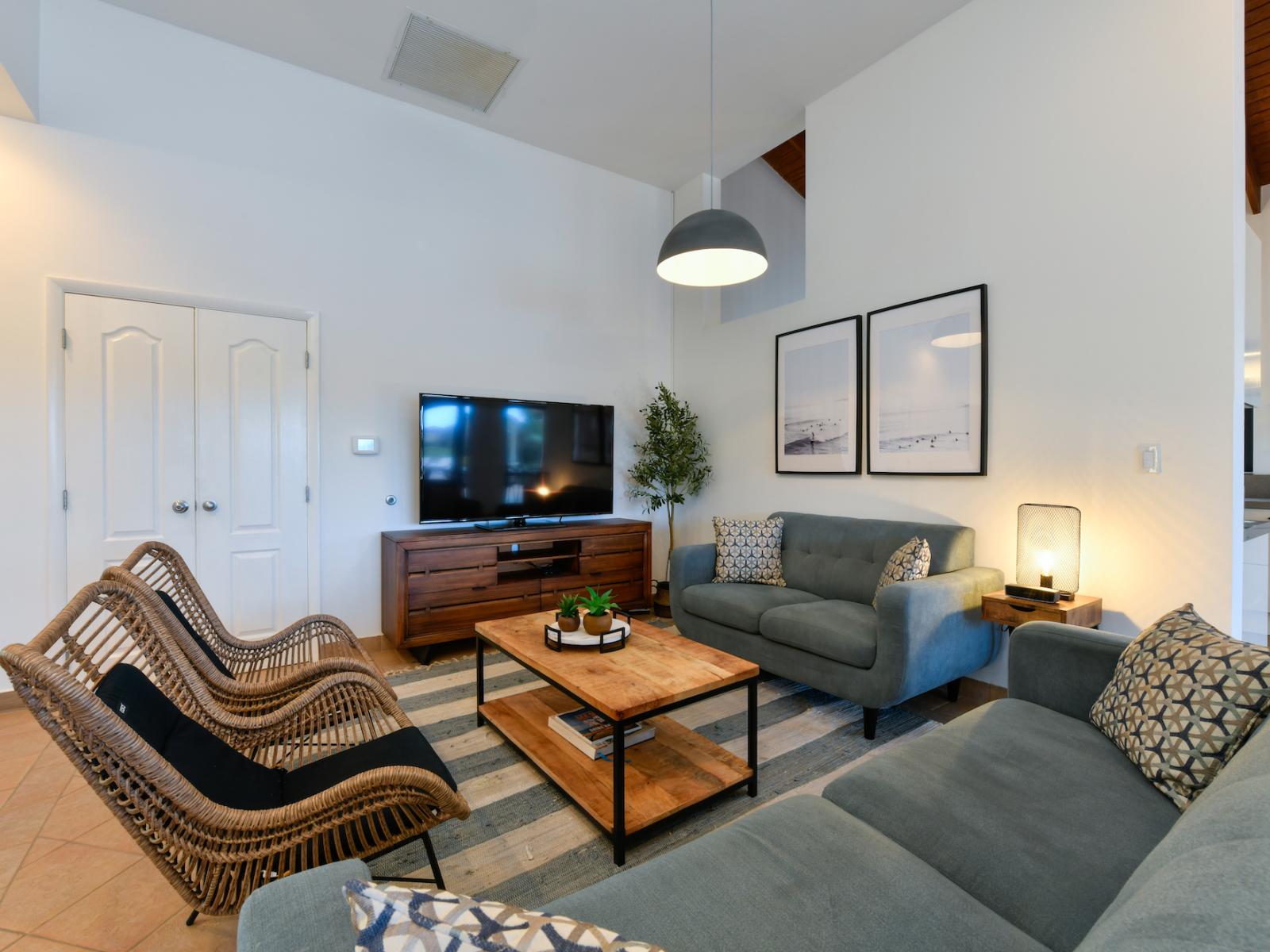 Living area has tall ceilings above and cool tile flooring