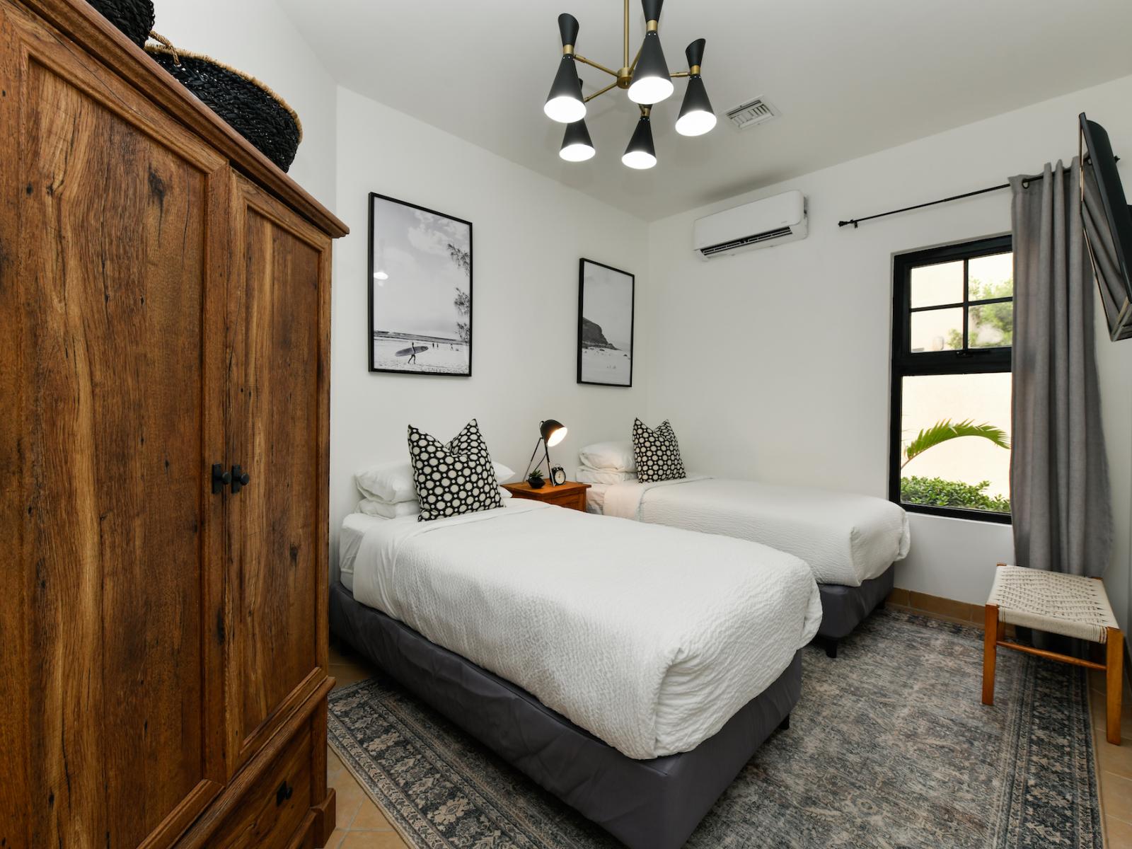 Opulent single beds bedroom of the villa in Noord, Aruba - Comfy 2 single beds - Elegantly designed room beautifully decored with aesthetic wall paintings - Majestic table lamp - Neat and clean linen with soft pillows - Beautiful wooden wardrobe