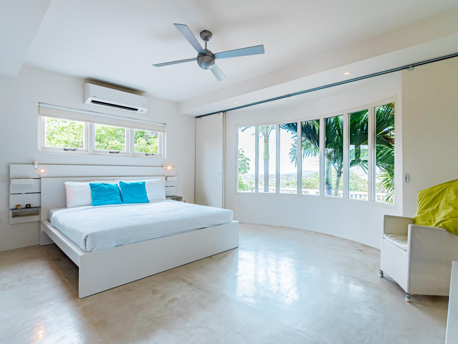 Luxurious Bedroom of the Home in Santa Cruz, Aruba - Cosy King size Bed and comfy sofa - Stunning large window of the bedroom with mesmerising views - Aesthetic ambiance - Majestic bed embossed lamps - Full light and airy room of the