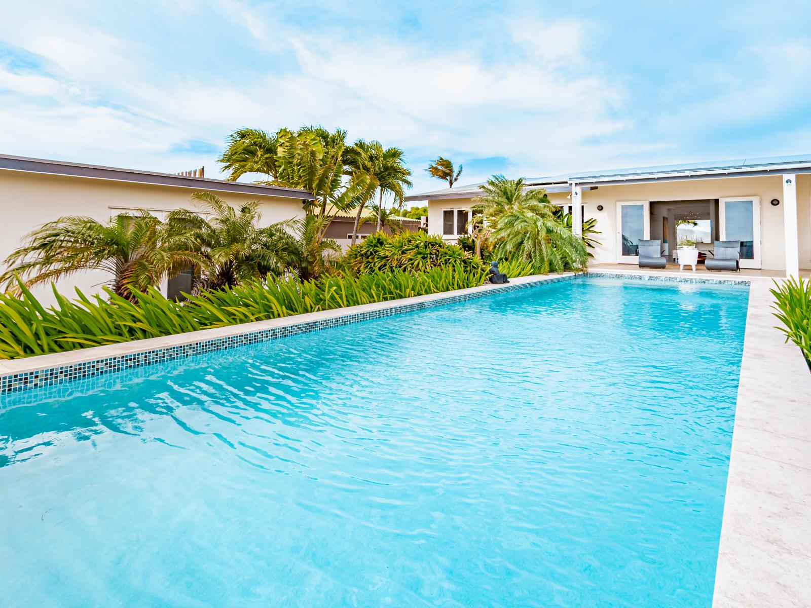 Resplendent Pool Area of the Home in Santa Cruz Aruba - Fencing or greenery for a secluded feel - Provides a relaxed atmosphere for unwinding - Space for swimming, games, and activities - Poolside chairs perfect for sunbathing and relaxation