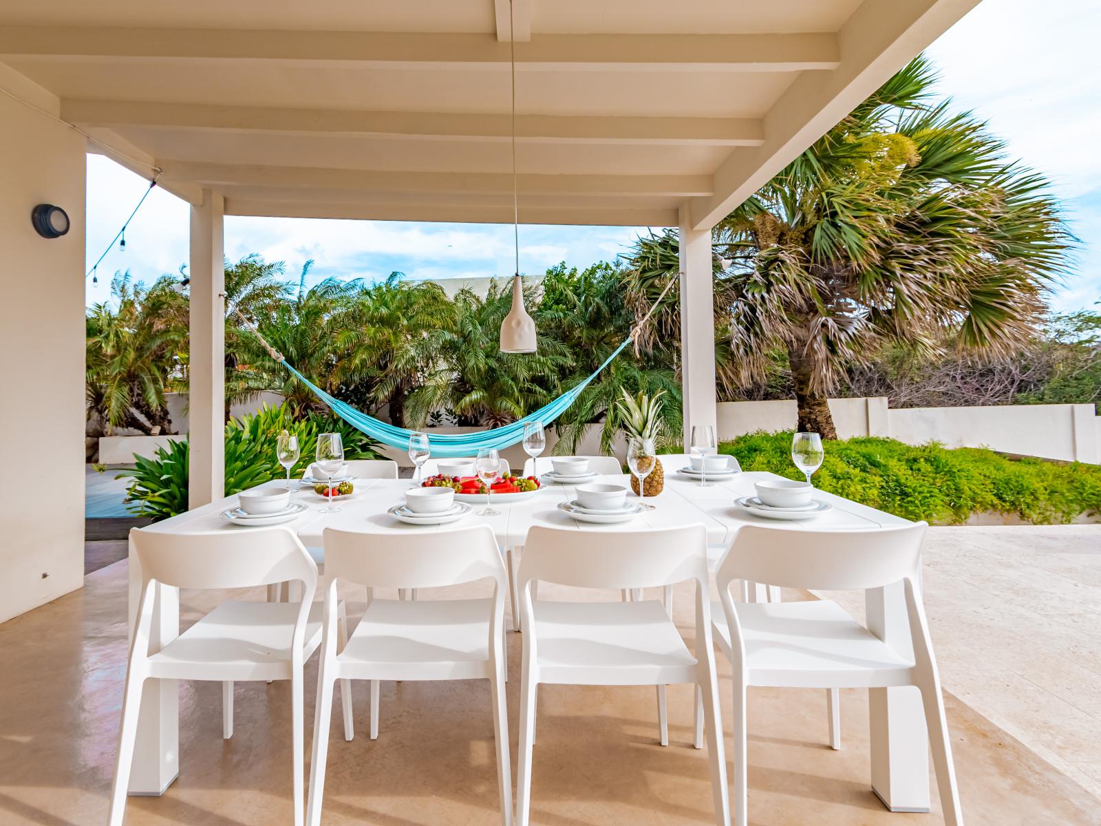 Refreshing Outdoor dining area of the Home in Santa Cruz Aruba - Gather 'round for al fresco feasts! - Share delicious meals  - create cherished memories - Hanging hammock for ultimate relaxation