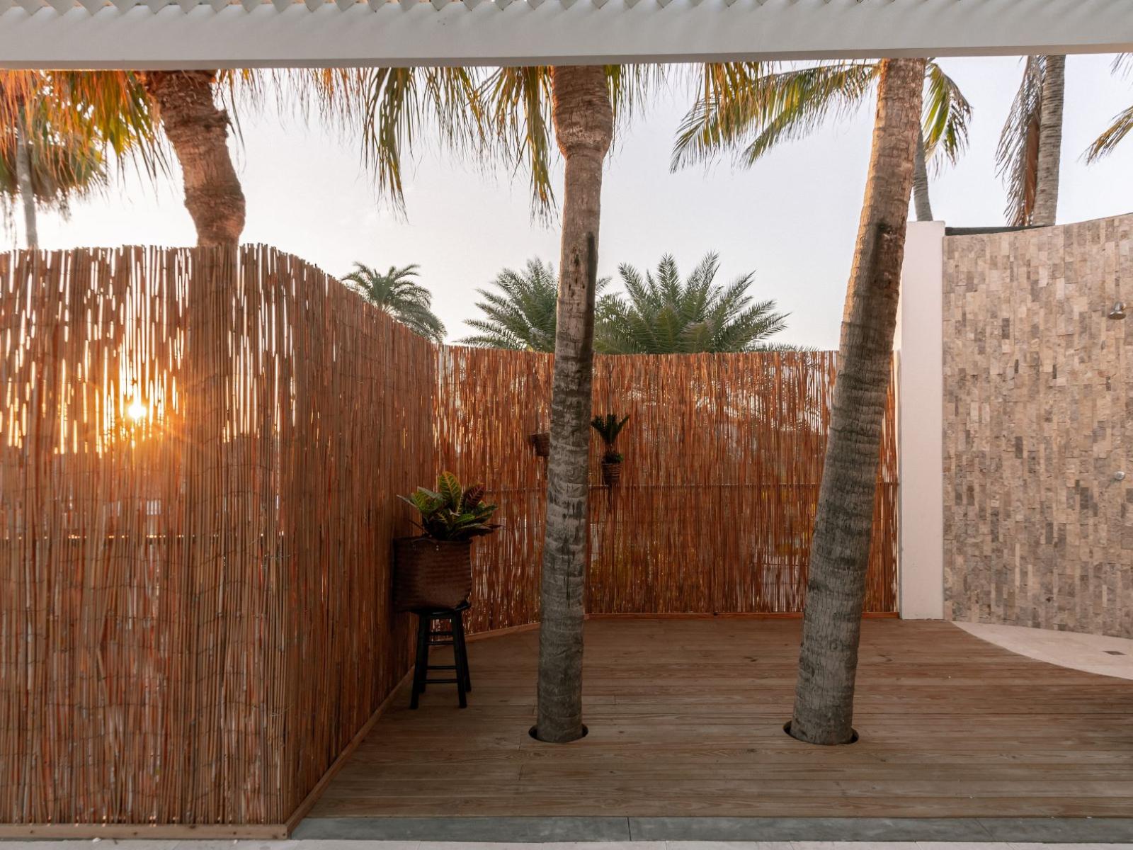 Outdoor Shower area with palm trees growing from the floor