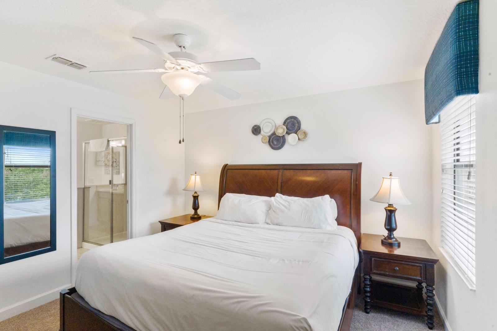 Refreshing bedroom that showcase a beautiful queen size bed and contain matching nightstands.