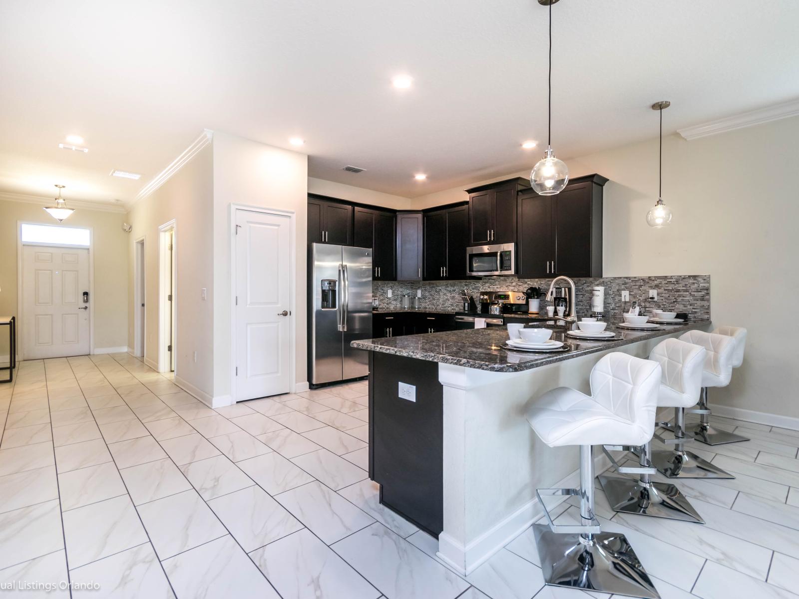 Inviting Kitchen of the Home in Davenport Florida - This modern kitchen comes with beautiful granite counter tops  - Stainless steel appliances, along with everything you need to cook up - High Chairs and Breakfast bar