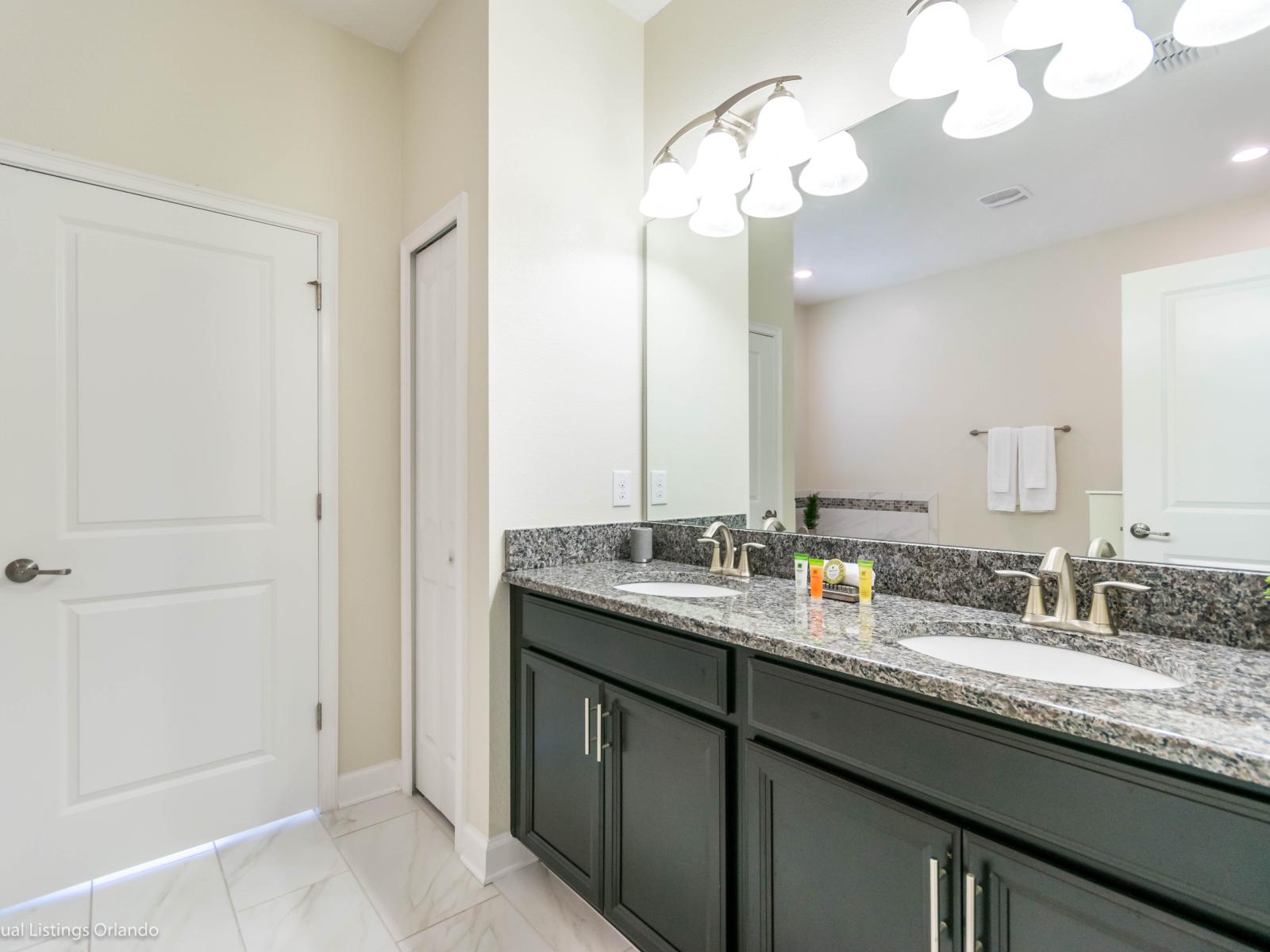 Monumental Bathroom of the Home in Davenport Florida - Dual Vanity area epitomizes modern elegance and sophistication with large mirror - With its sleek design and contemporary finishes