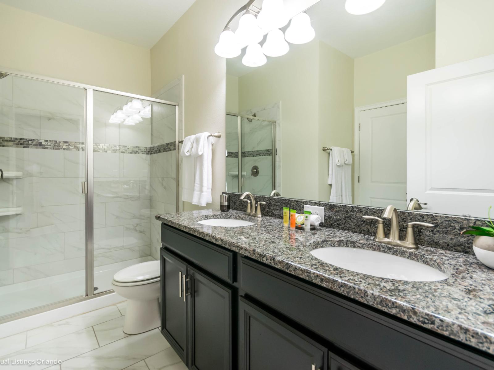 Monumental Bathroom of the Home in Davenport Florida - Dual Vanity area epitomizes modern elegance and sophistication with large mirror - With its sleek design and contemporary finishes