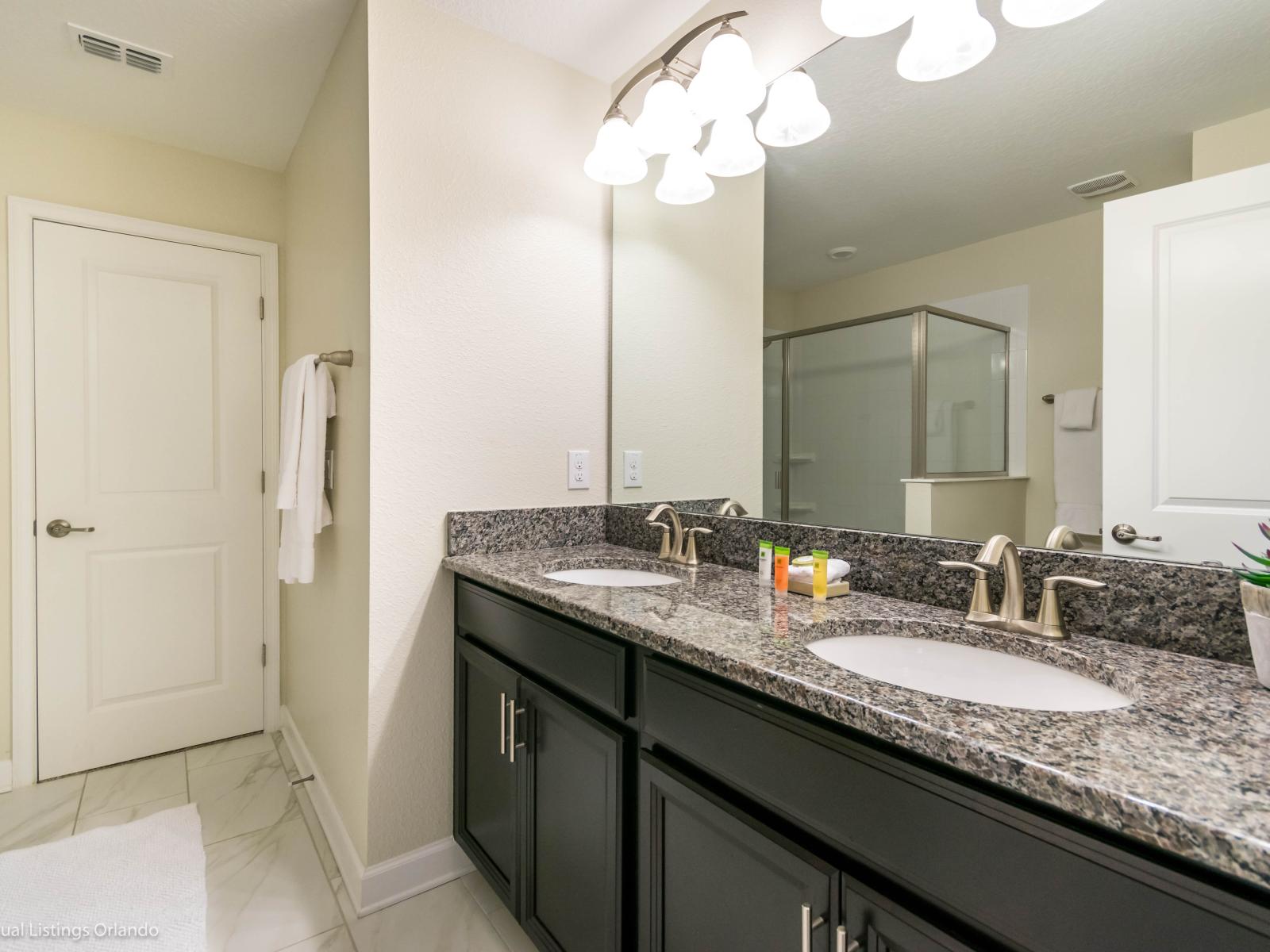 Big and spacious bathroom of the Home in Davenport Florida - Chic vanity with large mirror and upscale lighting - Elegant bathroom with luxurious fixtures and finishes