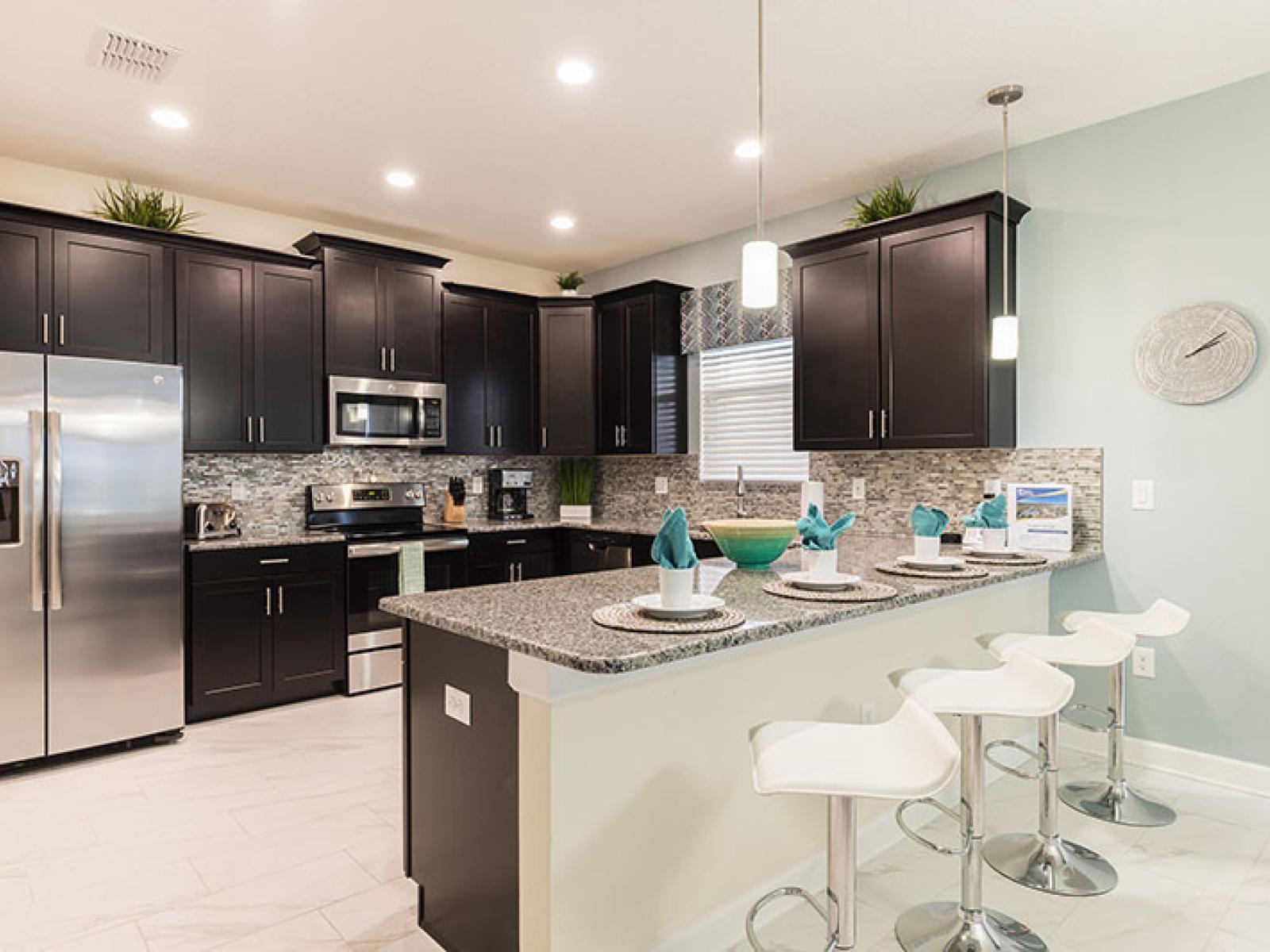 Sleek kitchen of the Home in Davenport Florida - Comes with beautiful granite counter tops and stainless steel appliances - Fully Equipped - High Chairs and Breakfast bar