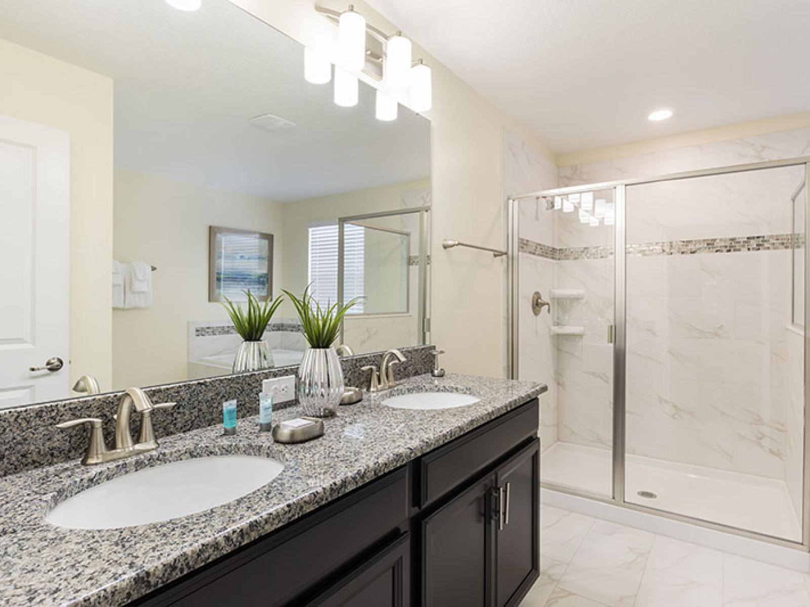 Polished Bathroom of the Home in Davenport Florida - Chic design featuring a sleek vanity and upscale lighting - Sophisticated color palette creating a serene ambiance - Glass-enclosed shower Area