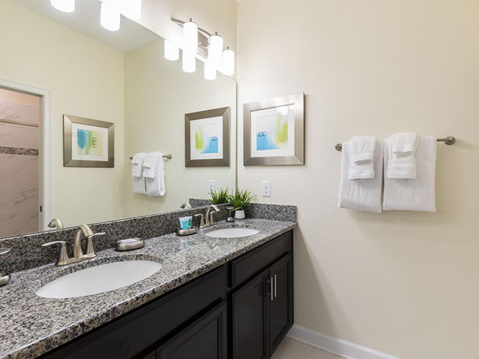 Polished Bathroom of the Home in Davenport Florida - Chic design featuring a sleek vanity and upscale lighting - Sophisticated color palette creating a serene ambiance - Glass-enclosed shower Area