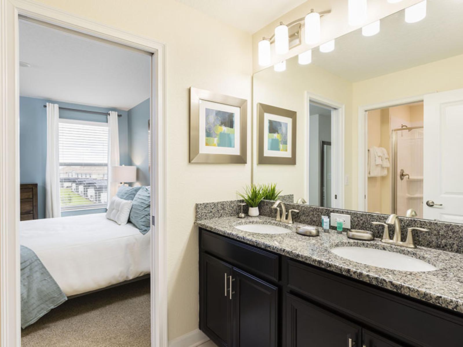 Chic Bathroom of the Home in Davenport Florida - Sophisticated color palette creating a serene ambiance - Lush design featuring a sleek dual vanity and upscale lighting - Contemporary fixtures for a touch of indulgence