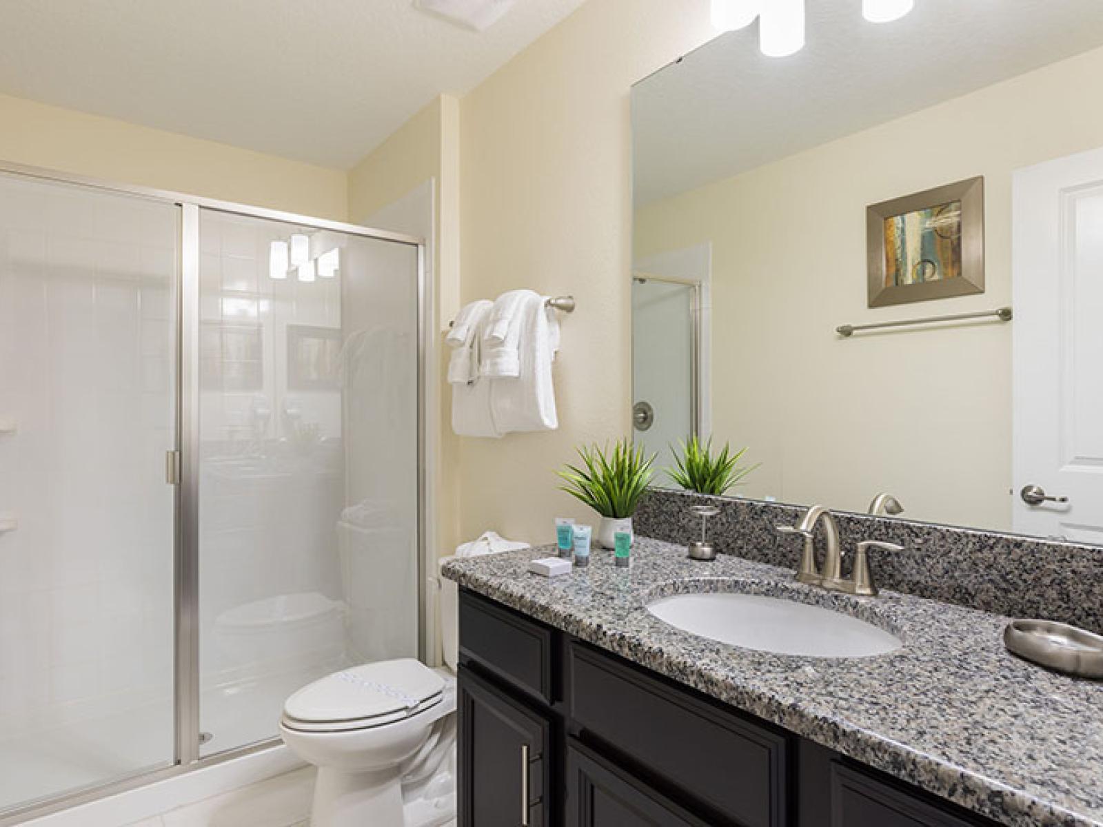 Luxe Bathroom of the Home in Davenport Florida - Elegant bathroom with luxurious fixtures and finishes - Chic design featuring a sleek vanity and upscale lighting - Seamless design featuring a glass-enclosed shower for a modern touch