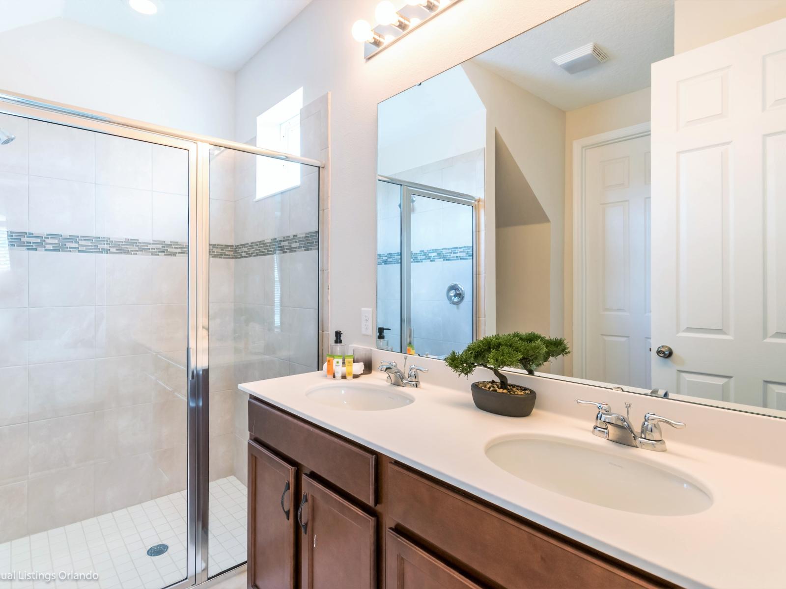 - Classy Bathroom of the apartment in Kissimmee - Beautiful Vanity with large size wall mirror - Sufficient storage space - Neat and clean toilet seat - Availability of all bathroom amenities - Stunning glass cabin shower area