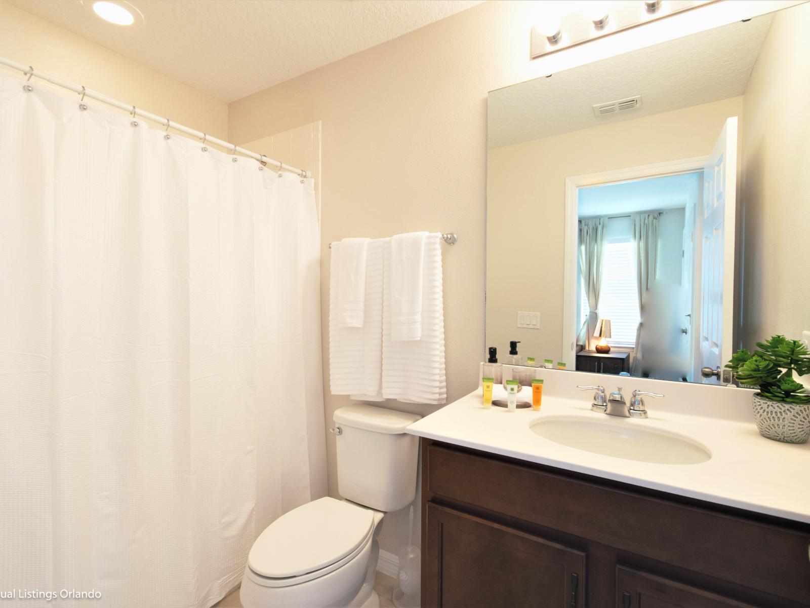 - Classy Bathroom of the apartment in Kissimmee - Beautiful Vanity with large size wall mirror - Sufficient storage space - Neat and clean toilet seat - Availability of all bathroom amenities - Stunning shower area