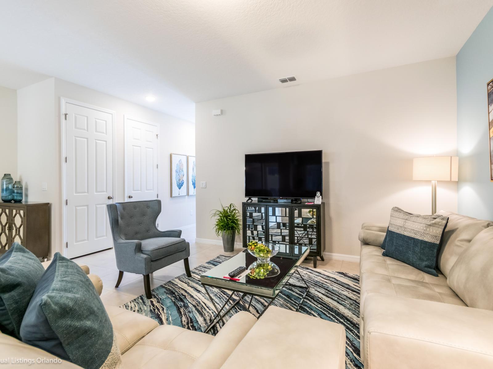 Luxe living area of the townhouse in Kissimmee Florida - Comfort takes center stage, inviting you to relax - Smart TV for entertainment - Thoughtful mix of textures, from plush rugs to tasteful throw pillows - Comfy sofas