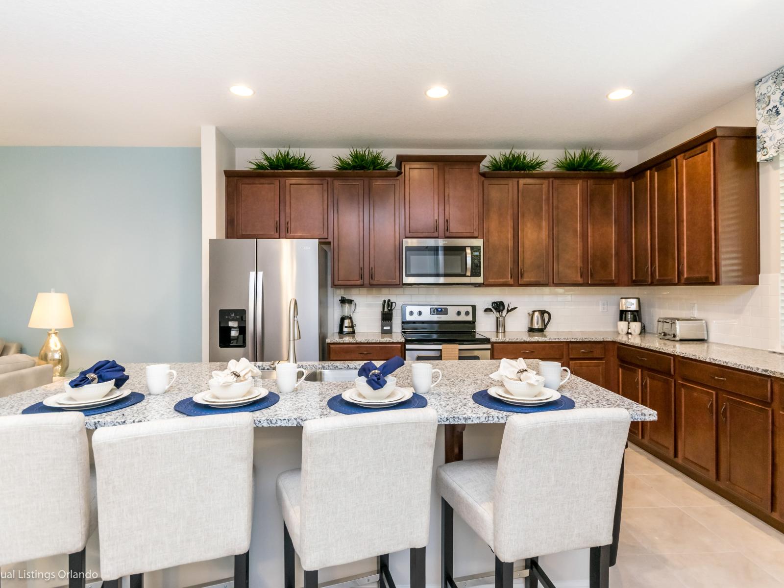 Sleek kitchen of the townhouse in Kissimmee Florida - Fully equipped - Thoughtful placement of kitchen essentials for easy access - Breakfast bar and high chairs - Smart use of space with versatile storage solutions - Stainless steel appliances