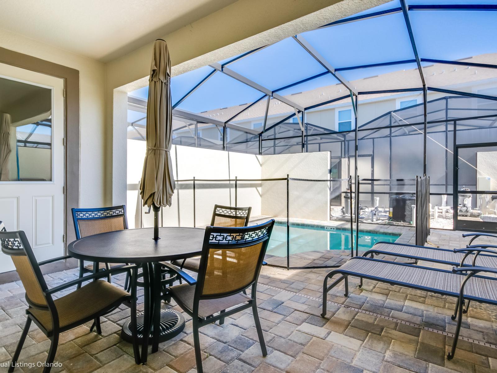 Refreshing outdoor sitting area  of the townhouse in Kissimmee Florida  - A charming space to unwind and enjoy the pool - Inviting spot offers a cozy and tranquil atmosphere for relaxation - Unwind in our outdoor haven, where every meal is a breeze