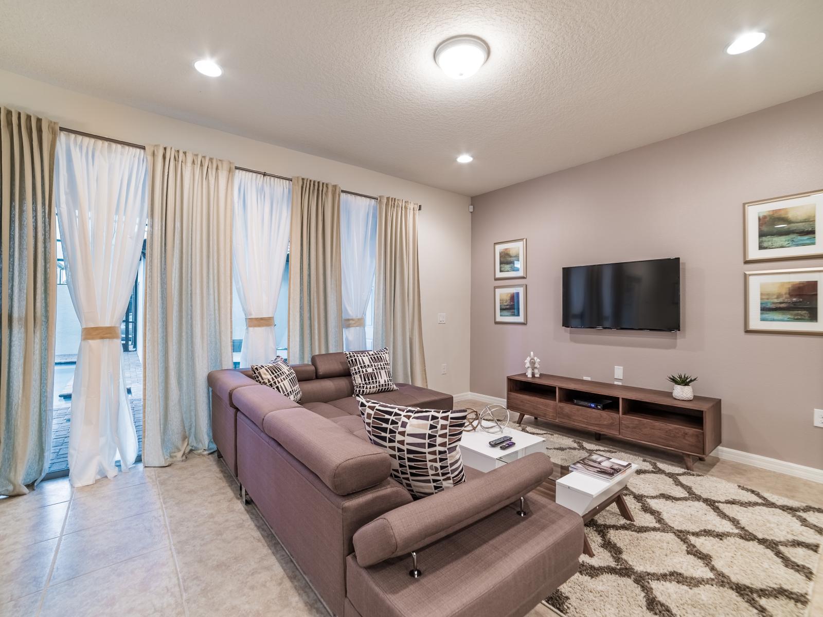 Open-concept living area of the townhouse in Kissimmee, Florida -  Comfortable seating in the living area that convey a sense of relaxation -  Presence of natural light can enhance the overall ambiance - Smart tv with Netflix