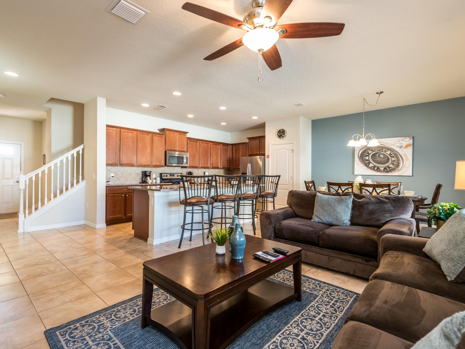 The living room and kitchen unite in perfect harmony, creating a space where comfort and functionality converge, inviting shared moments and culinary delights in a setting of contemporary elegance.