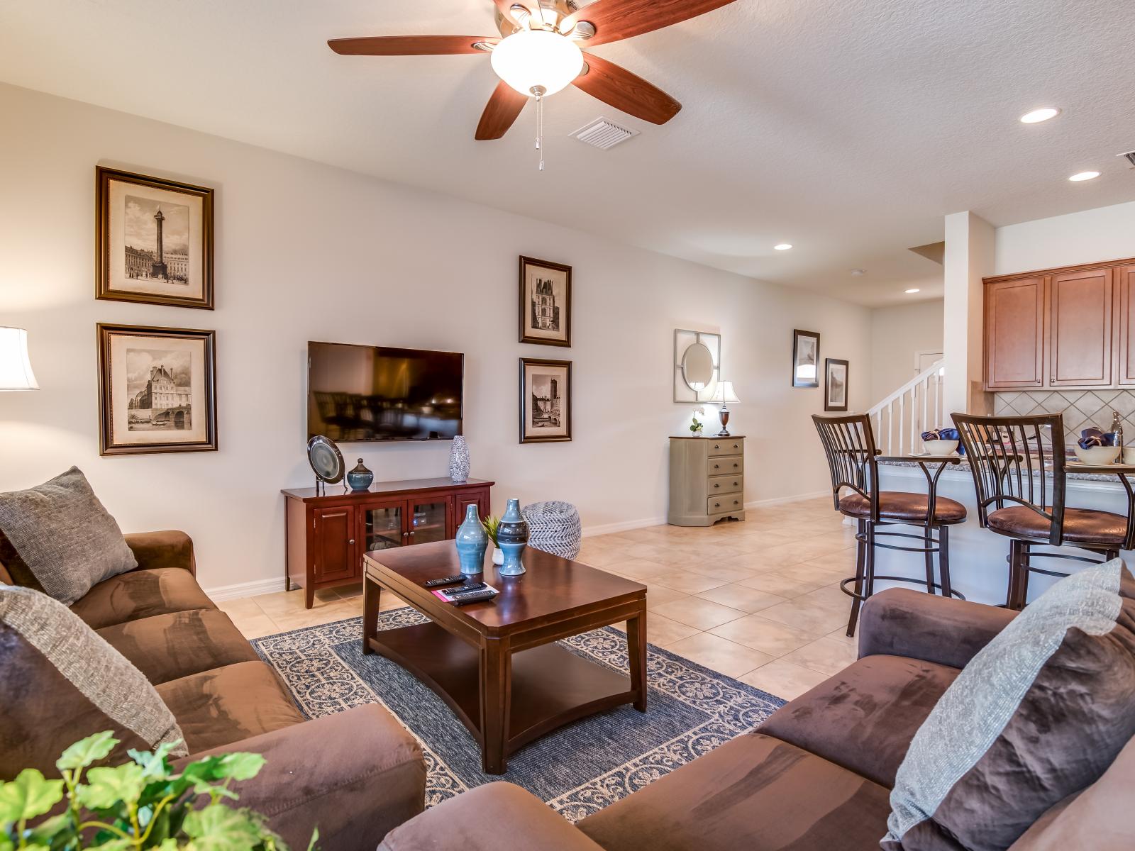 This living room and kitchen blend together seamlessly, creating a welcoming space where the joys of cooking and relaxation come together, fostering cherished moments and connections.