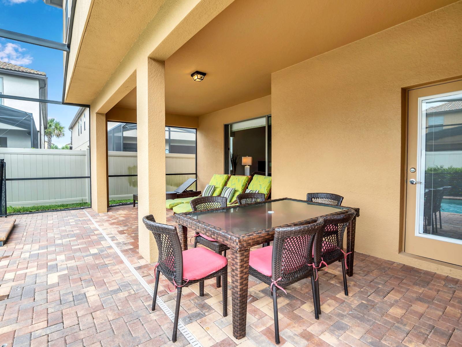 Indulge in outdoor bliss: Discover our screened-in lanai with a patio table, inviting lounge chairs, and a serene pool – your perfect getaway spot.