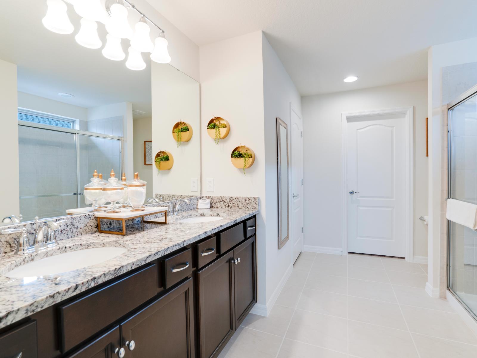 Elite Bathroom of the apartment in Kissimmee - Beautiful Vanity with large size wall mirror - Sufficient storage space - Neat and clean toilet seat - Availability of all bathroom amenities - Stunning glass cabin shower area - Neat and cosy Bathtub