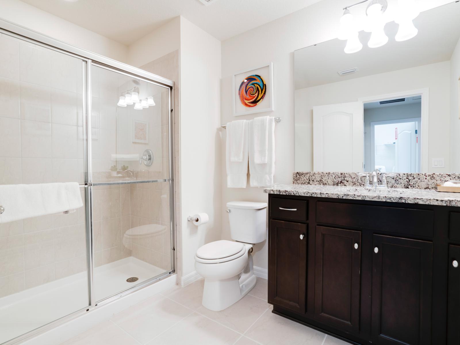 Exclusive Bathroom of the apartment in Kissimmee - Beautiful Vanity with large size wall mirror - Sufficient storage space - Neat and clean toilet seat - Availability of all bathroom amenities - Stunning glass cabin shower area