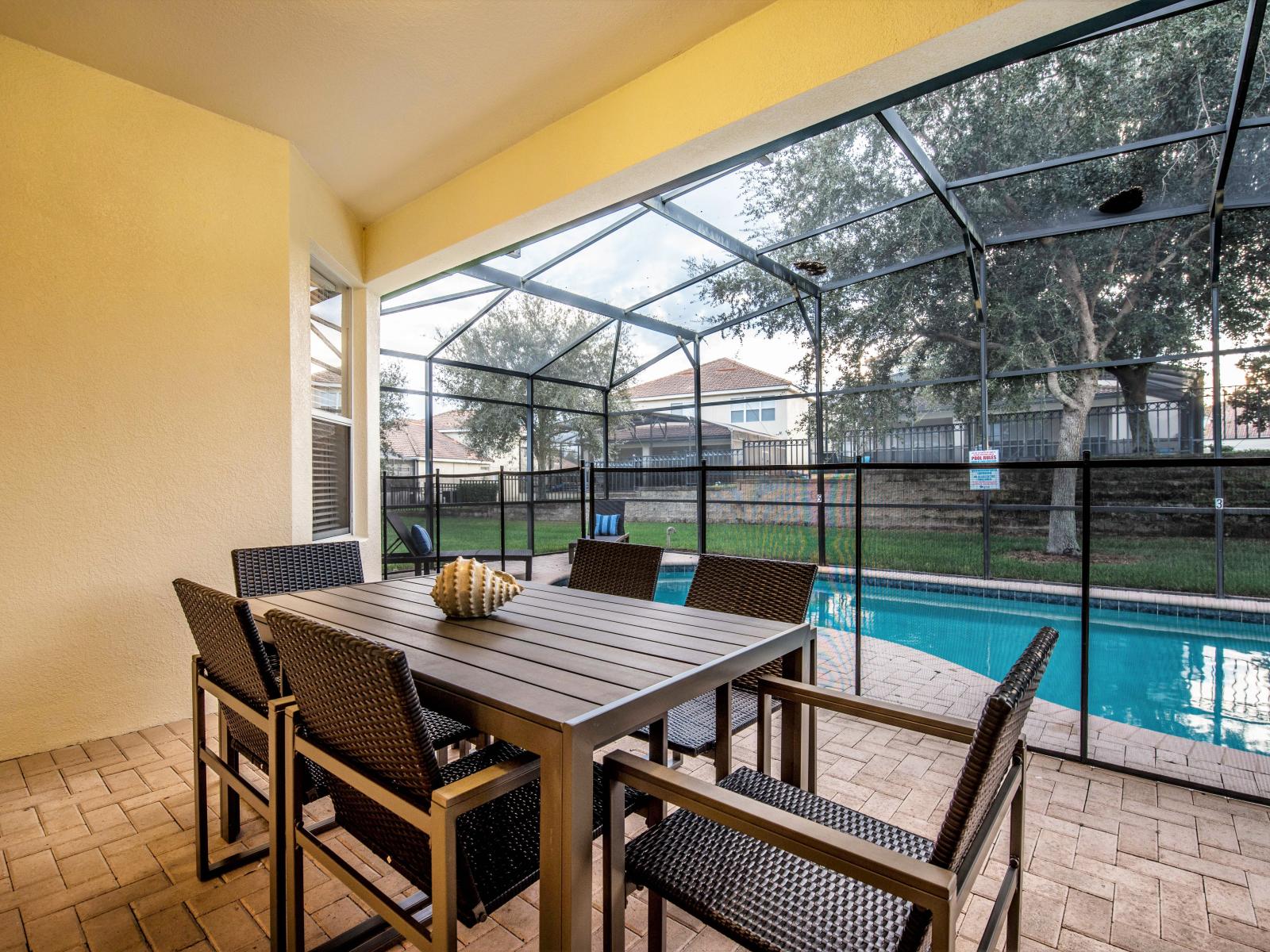 Charming 6 persons patio dining area of the home in Kissimmee, Florida - Experience unforgettable meals amidst picturesque views and refreshing breezes - Enjoy the convenience of fresh water throughout the stay