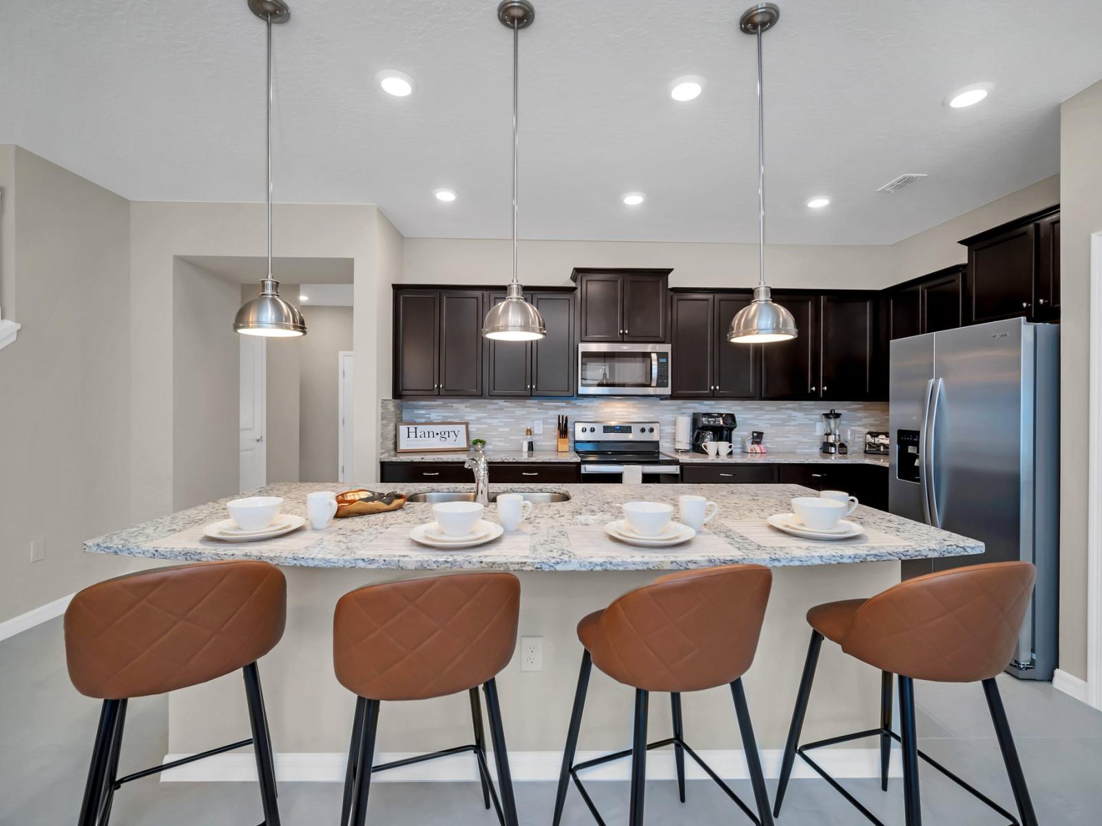 Contemporary open concept Kitchen with countertop and high chairs for a quick coffee or snack fronting the living room