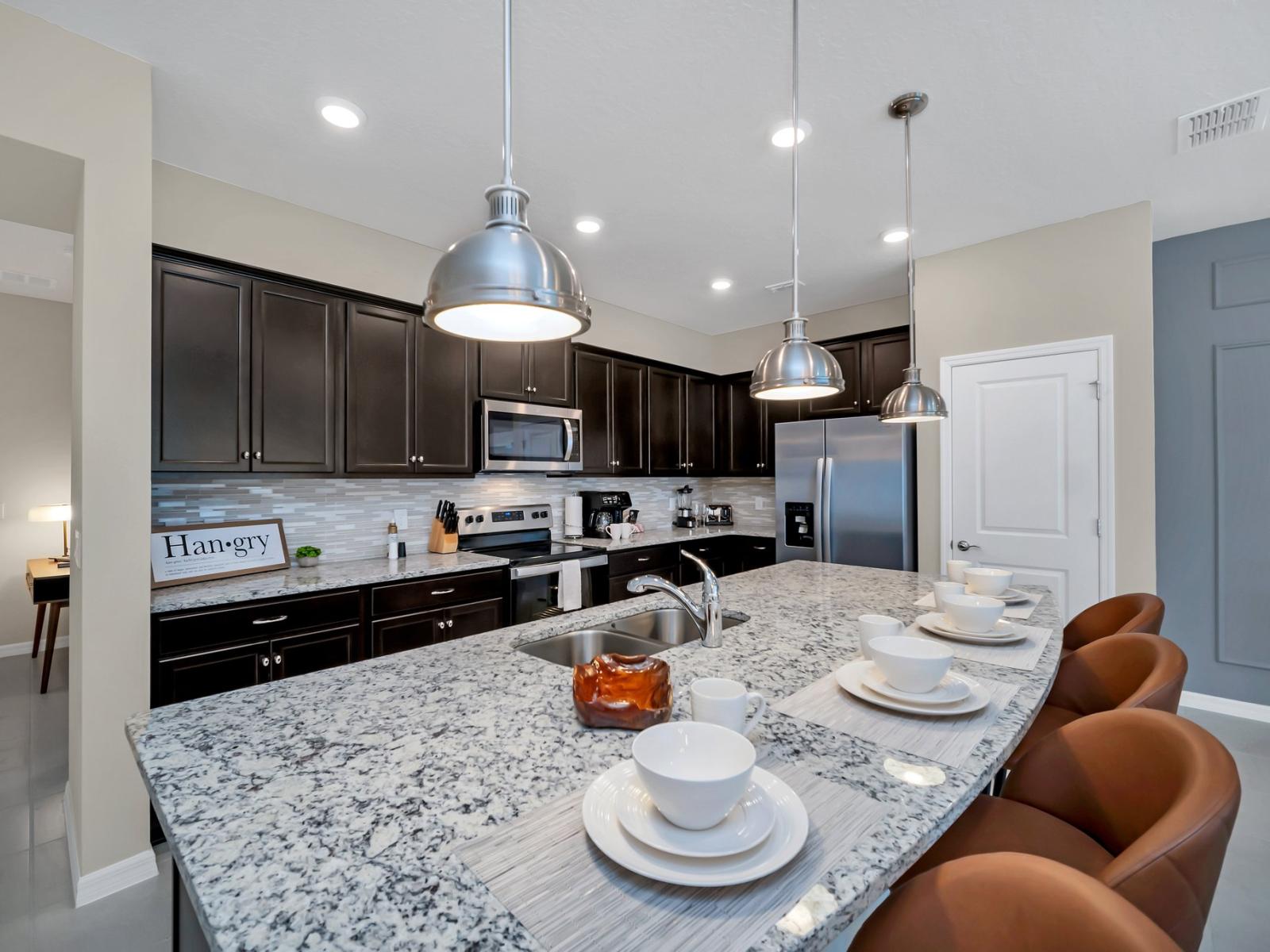 Modern open-plan kitchen featuring a countertop with high chairs, perfect for enjoying a quick coffee or snack while facing the living area