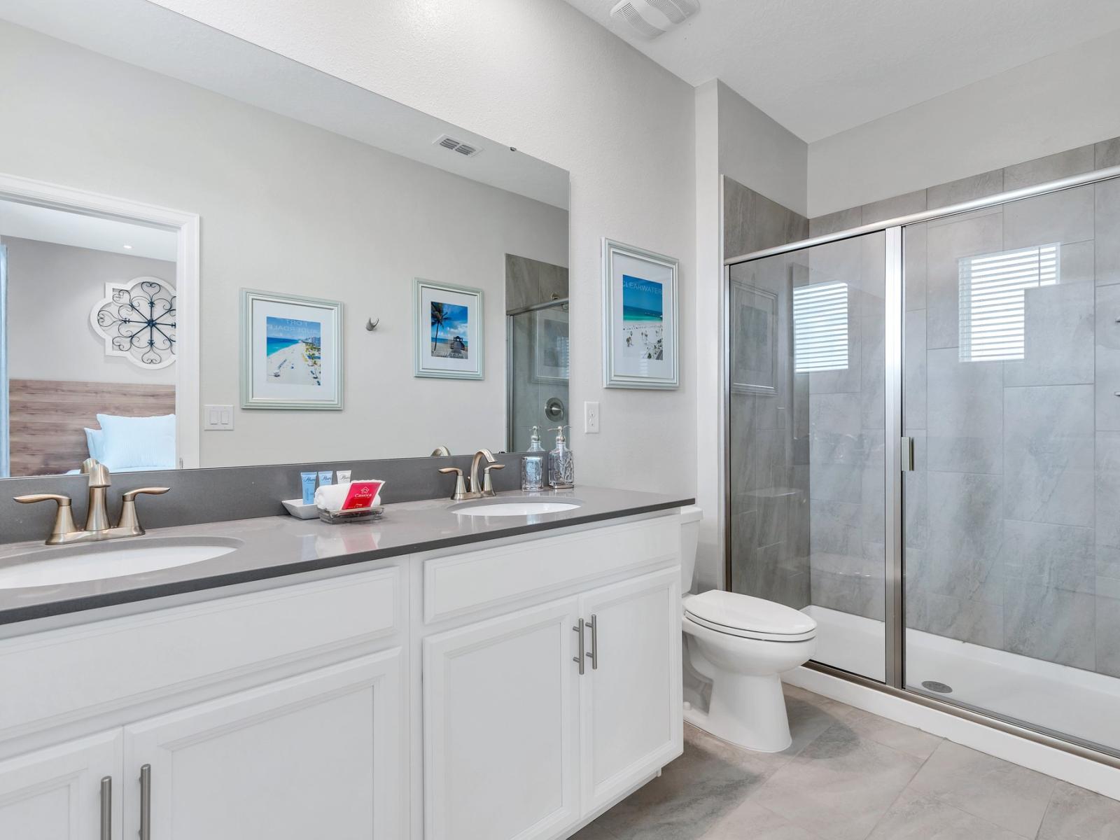 Polished bathroom of the home in Kissimmee Florida - Chic design featuring a sleek vanity and upscale lighting - Spacious walk-in shower stall - Understated elegance with clean lines and refined details