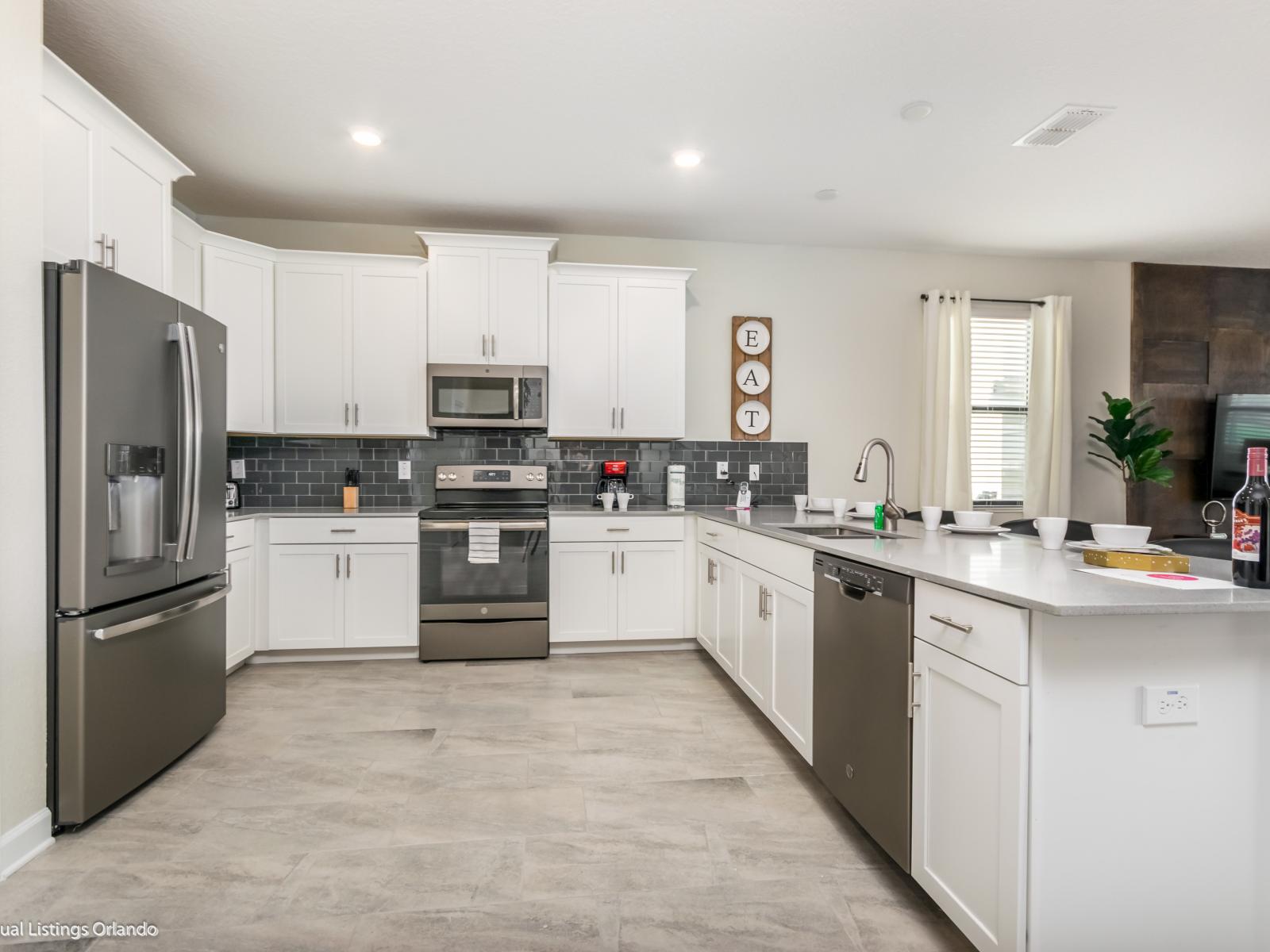 Modern kitchen of the home in Kissimmee Florida - Stainless steel appliances - Contemporary design with clean lines and minimalist aesthetics - Chic backsplash adding a touch of personality to the space