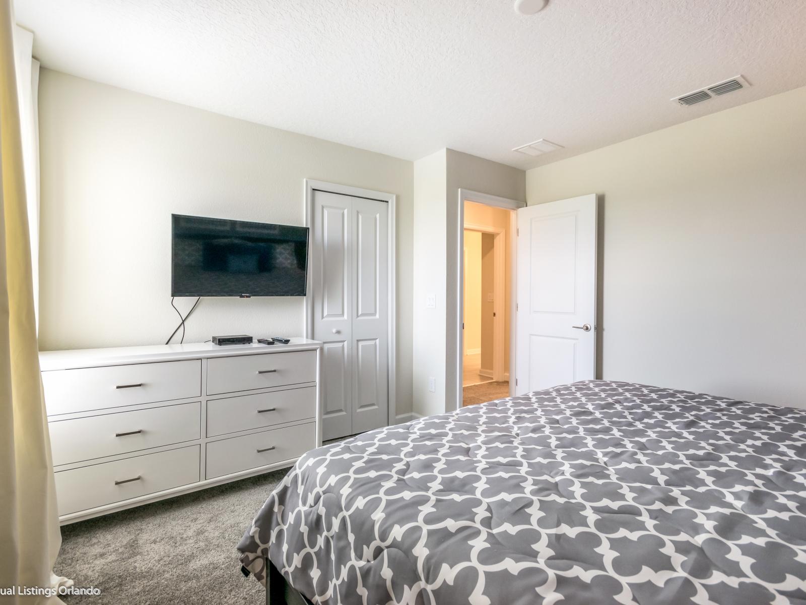 Modern Serenity: Bedroom Enhanced by a Subtle Gray Accent Wall, Accompanied by Two Bedside Tables Illuminated by Elegant Lamps.