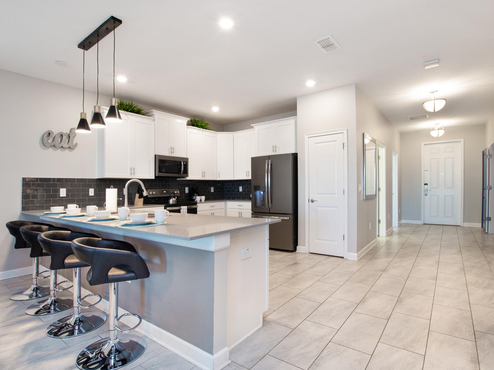 Kitchen fronting the countertop table with four high chairs- either a quick coffee or snack this is the perfect place to sit