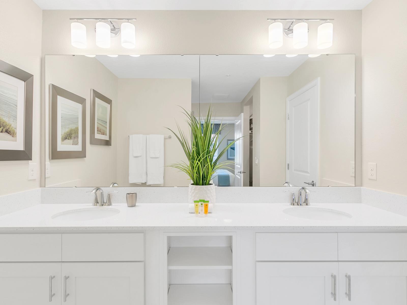 - Exclusive Bathroom of the condo in Kissimmee - Lovely twin sink vanity with big size wall mirror and lamps - Fresh towels and all amenities available - Neat and clean toilet seat - Refreshing atmosphere throughout the stay