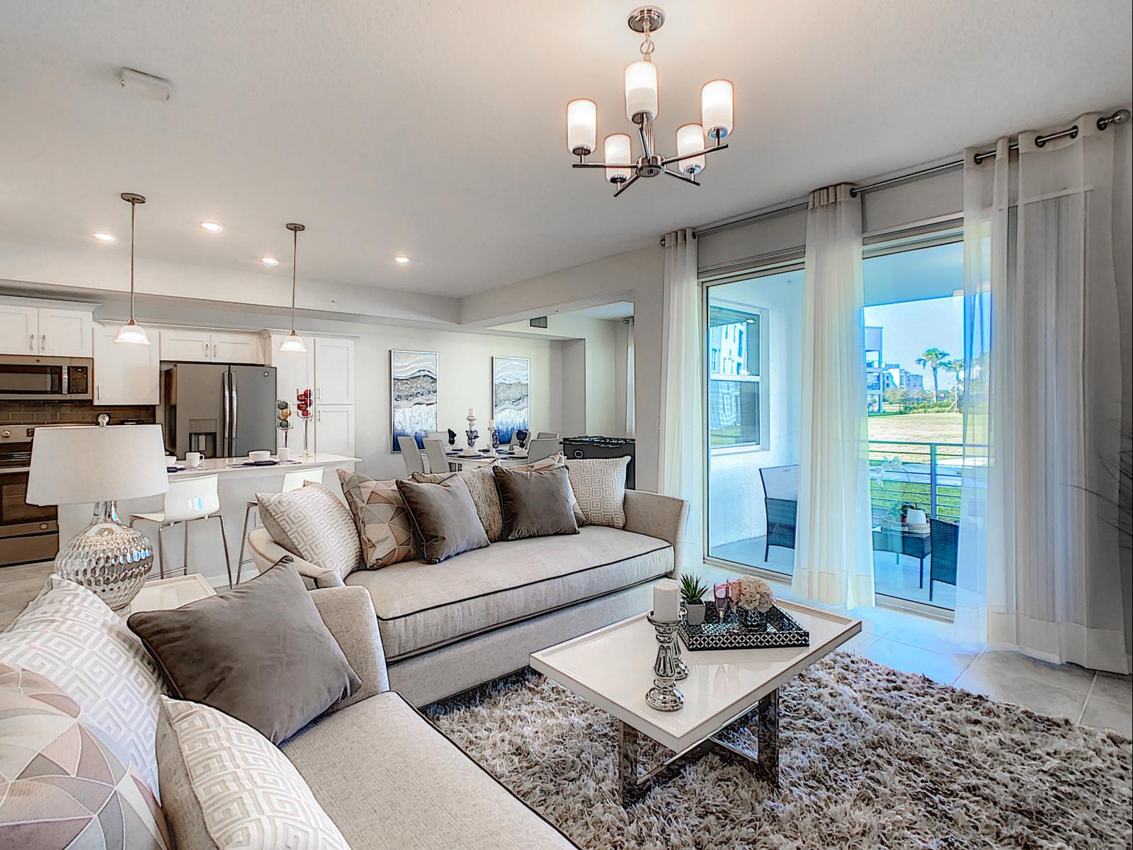 Spacious and elegant living area, perfect for relaxation and entertaining in style - Soft neutrals, cozy textures and lighting create a serene ambiance - Large sliding doors connect you to the outdoors, flooding the space with natural light