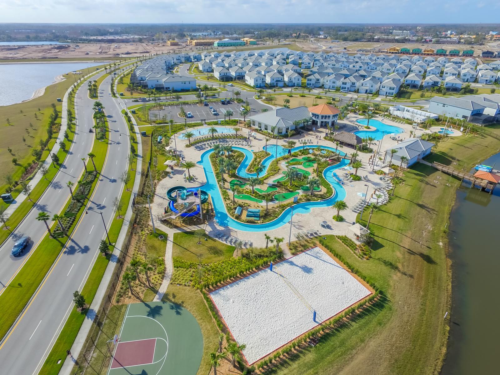 Aerial view of a resort paradise, with pools, sports courts, and lush landscaping.