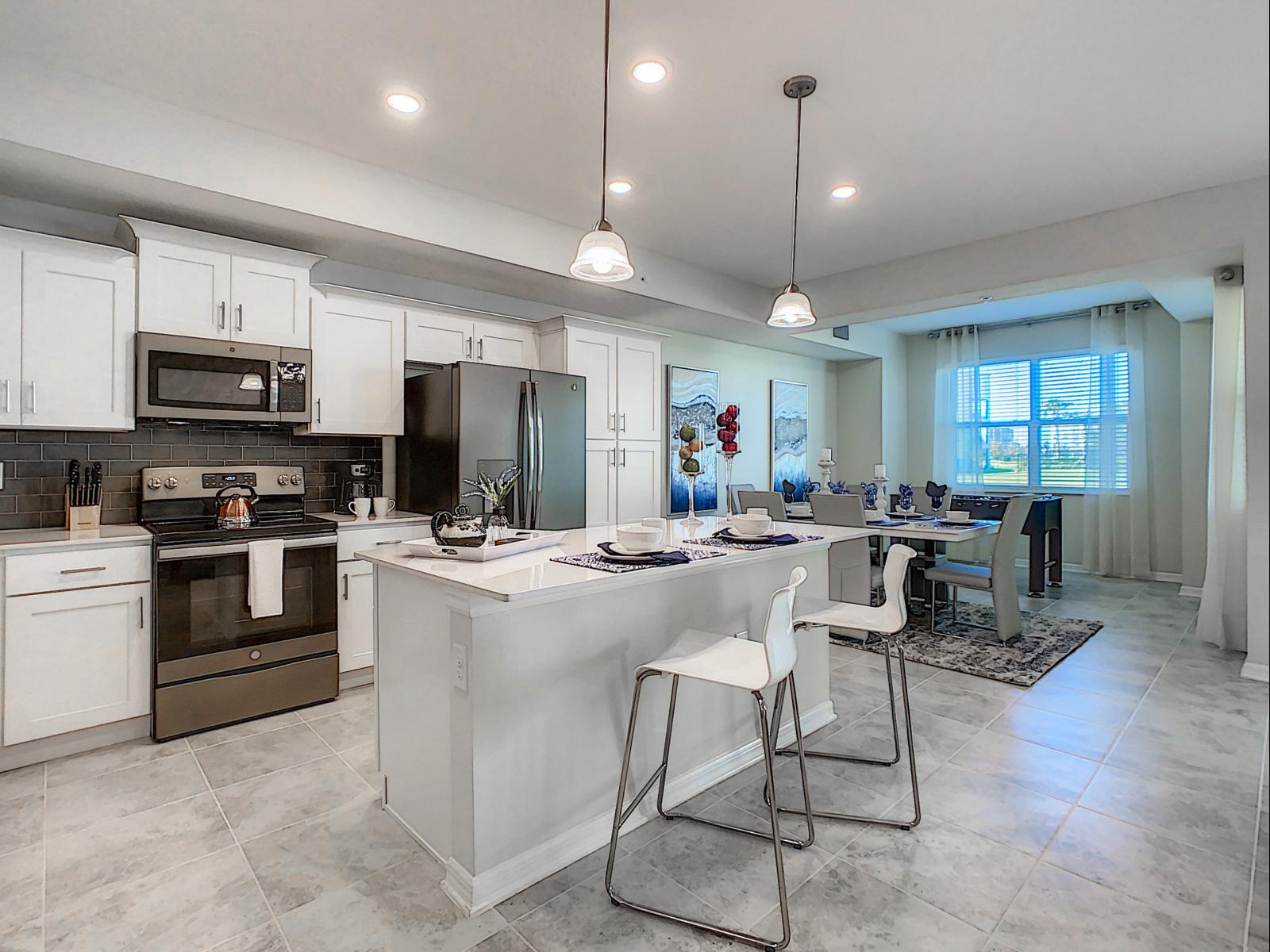 Well-equipped kitchen with a spacious island perfect for casual dining or meal prep - Airy, with sleek cabinetry and stainless steel appliances that add sophistication - Ideal gathering spot, blending function and style for cooking and connecting