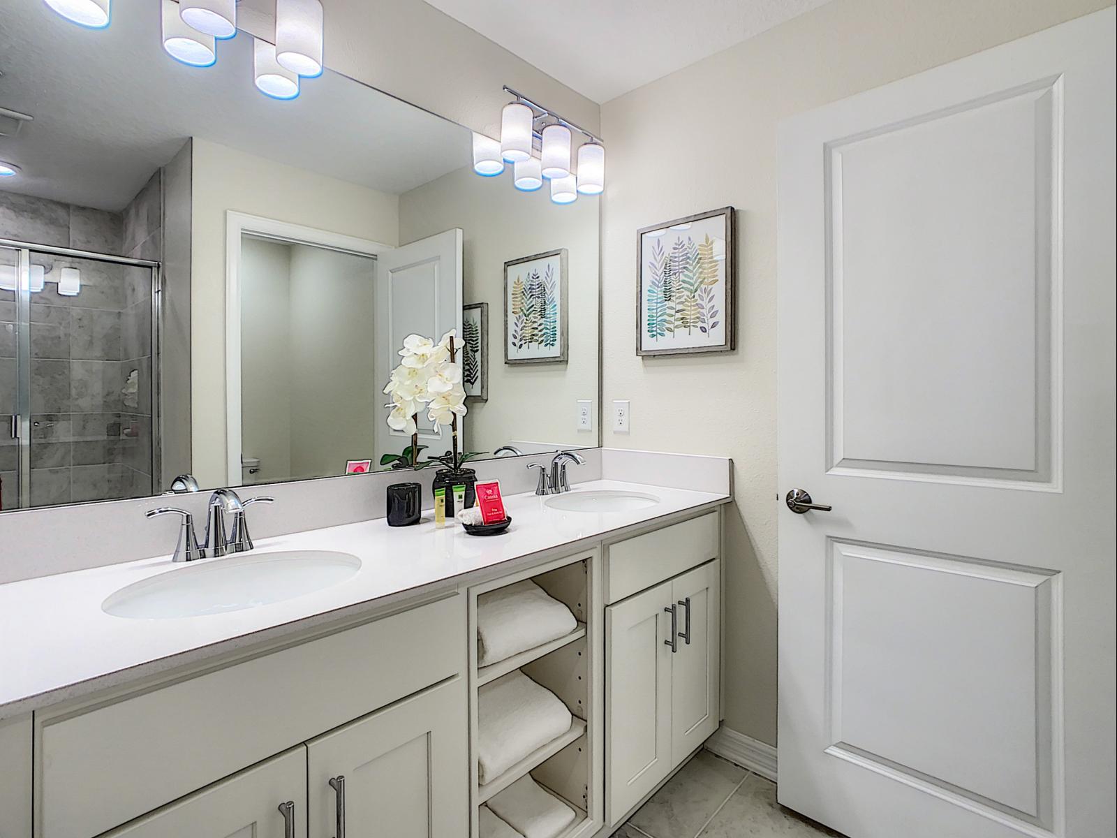 Elegant bathroom with a large double sink vanity, perfect for added convenience - Bright lighting and tasteful decor make this space both practical and chic - A blend of function and elegance, making daily routines feel like a treat