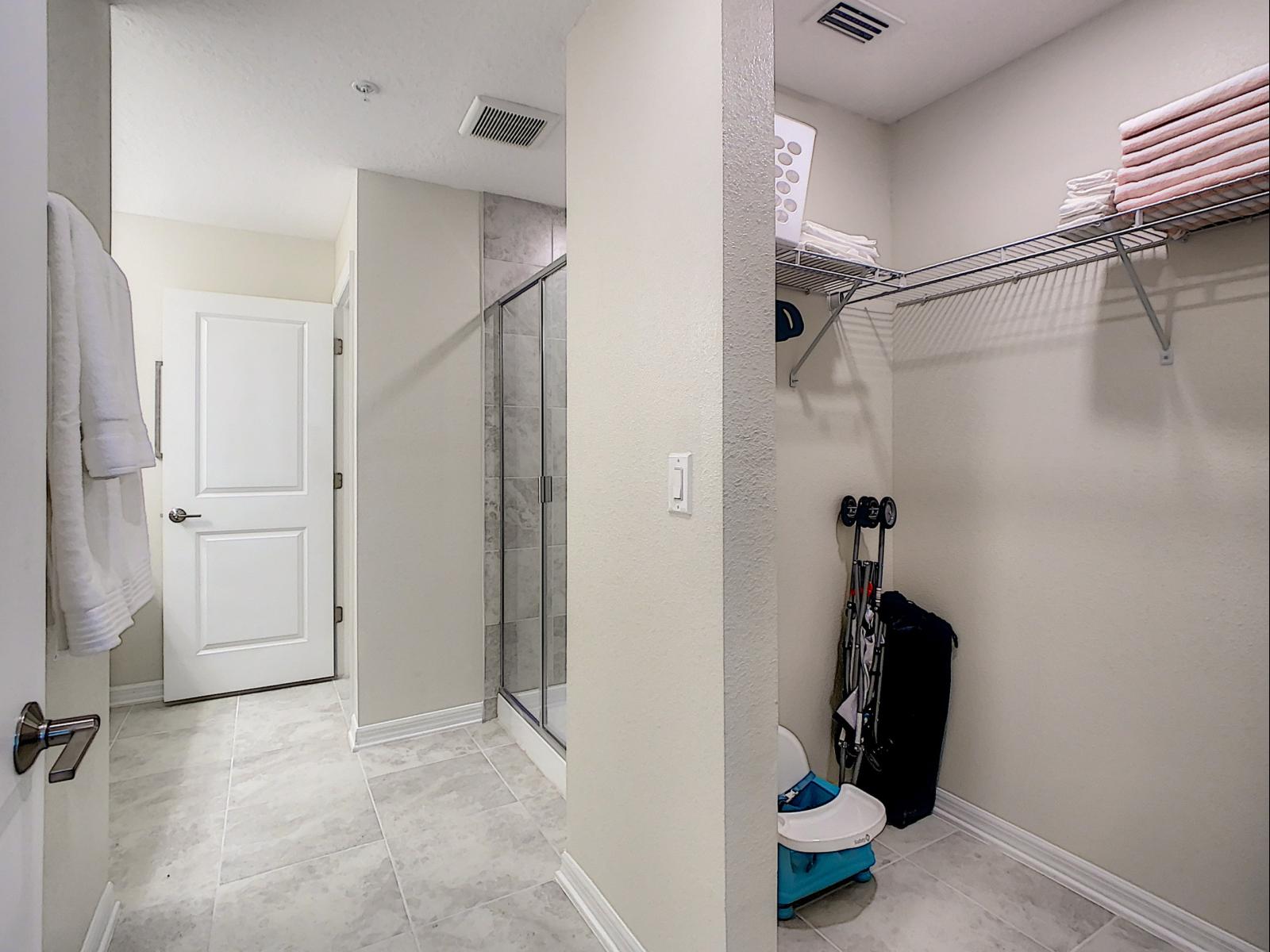 Spacious walk-in closet and bathroom combination, designed for ultimate convenience - Shelving and hanging space ensure everything has its place, making organization easy - Retreat with plenty of storage, ready to keep your essentials within reach