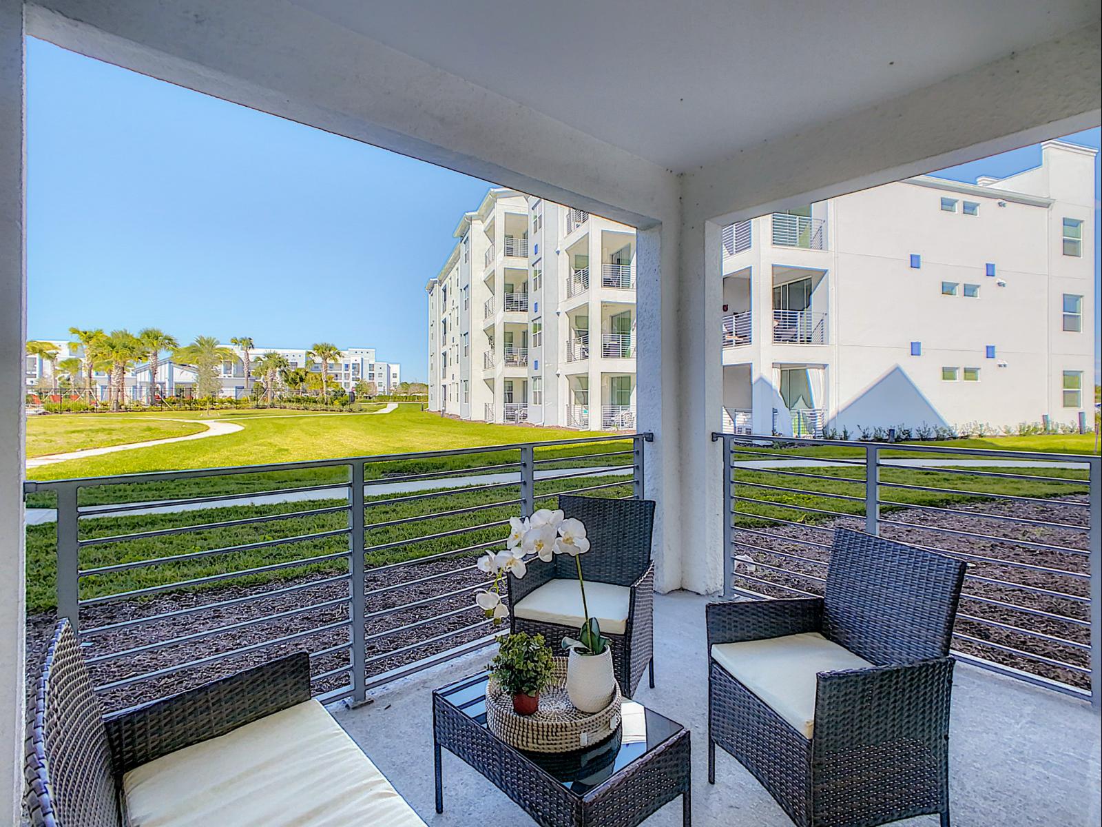 Enjoy the outdoors in this cozy, shaded patio with comfortable wicker seating - Perfect for morning coffee or evening relaxation with beautiful views of the green space - Private balcony oasis, offering fresh air and a calming atmosphere