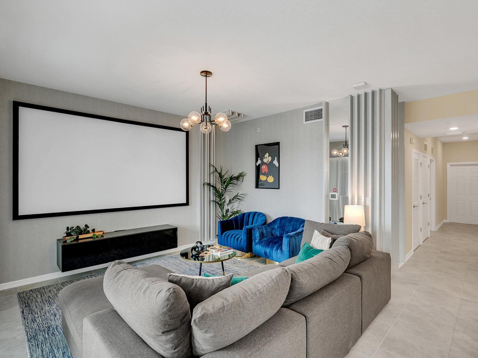 Enchanting living area of the condo in Kissimmee Florida - Well-chosen lighting fixtures adding both functionality and charm - Projector and large screen for entertainment - Stylish, contemporary furnishings enhancing the aesthetic