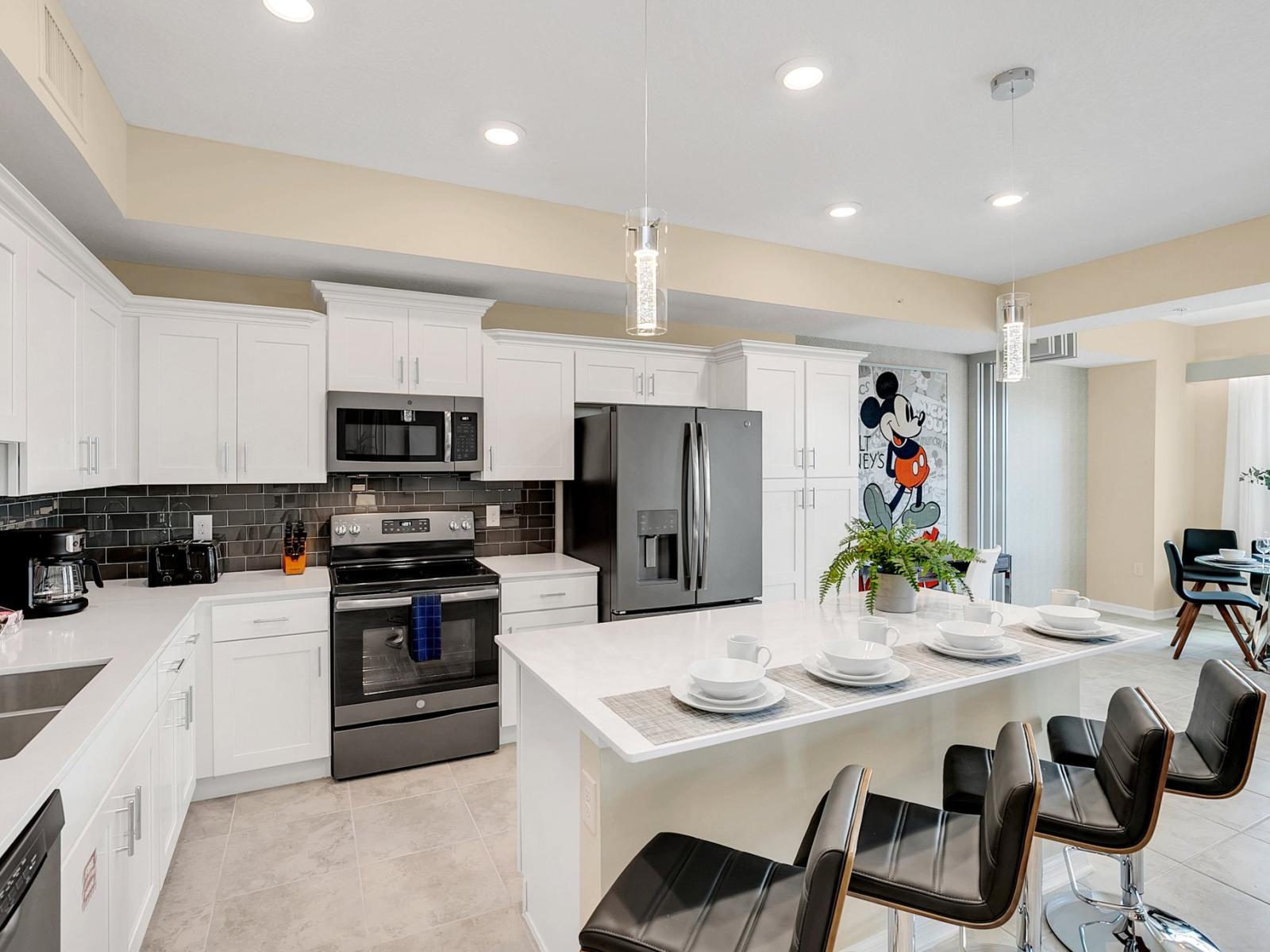 Modern kitchen of the condo in Kissimmee Florida - Breakfast bar and high chairs - Sleek stainless steel appliances - Plenty storage space for organized and clutter-free counters