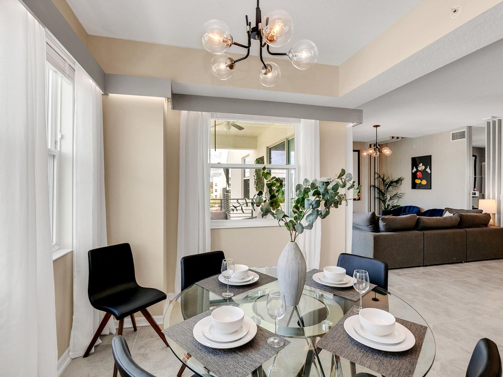 Alluring dining area of the condo in Kissimmee Florida - Artfully arranged table settings for a touch of elegance - Dining for 4 persons with an additional chair - Functional and aesthetically pleasing space