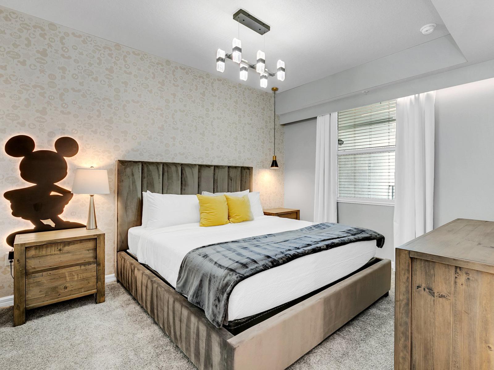 Charming bedroom of the condo in Kissimmee Florida - Enjoy a bedroom with playful charm and mickey mouse wall accent decor - Comfy king size bed for comfort - Thoughtfully designed bedroom featuring functional and stylish furniture