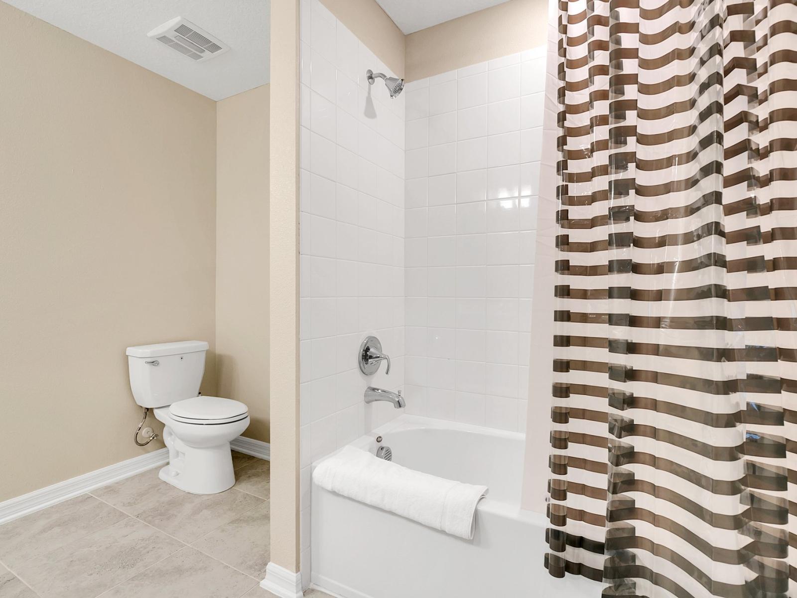 Toilet and Bathtub with Shower: A Relaxing Oasis for Refreshment and Renewal.