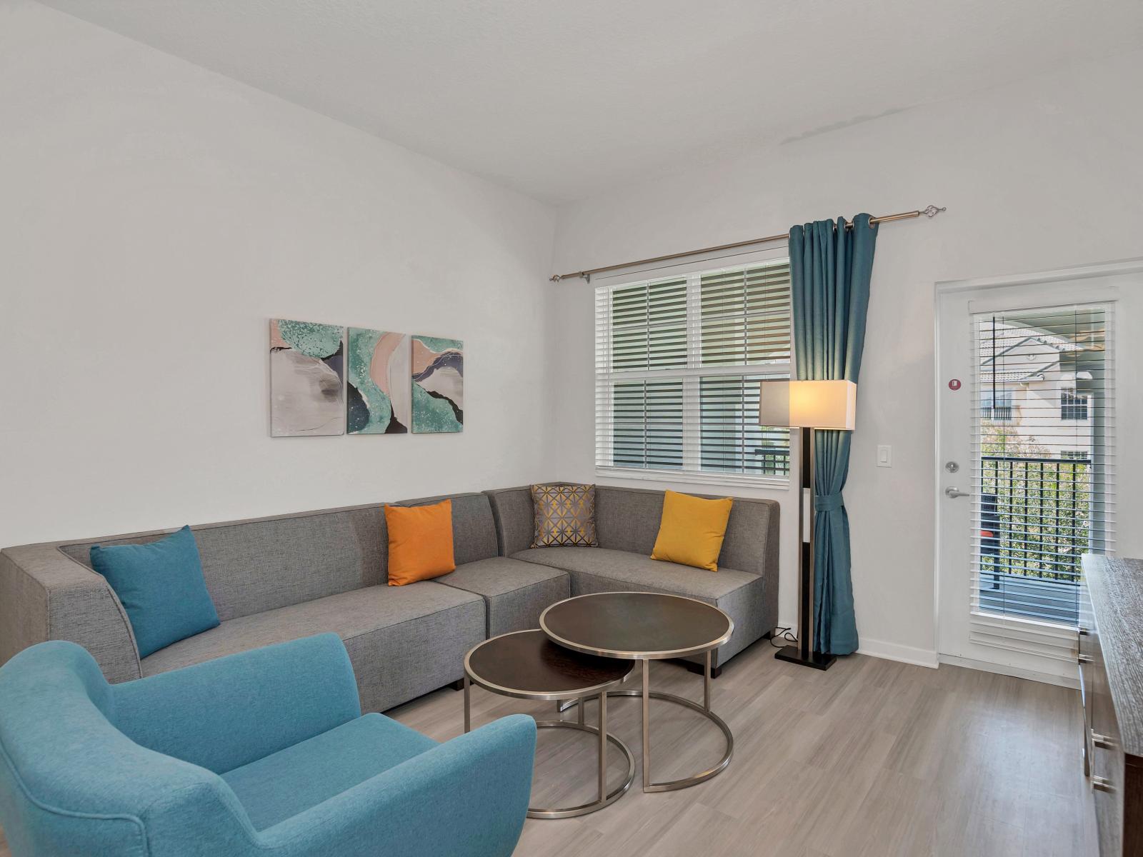 Luxurious living area of the condo in Orlando - Experience the convenience of outdoor patio from the living space - Plush and comfortable seating arrangements - Decored with aesthetic wall paintings